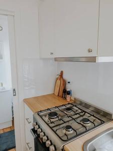 a kitchen with a stove top oven in a kitchen at Little Lodge - Luxury Tiny Home Stay in Alstonville