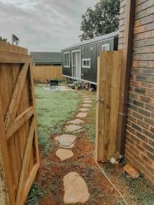 an open gate to a backyard with a trailer at Little Lodge - Luxury Tiny Home Stay in Alstonville
