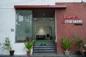 a hotel star grand entrance with stairs and plants at 5 STAR GRAND- PREMIUM in Shamshabad