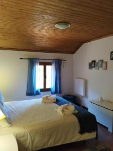 a bedroom with a large bed with blue curtains at Quinta Meneses in Santa Cruz