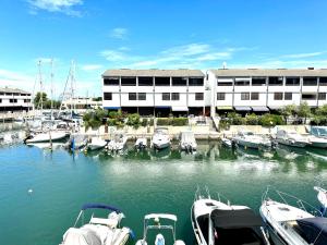 a group of boats docked in a marina with a building at Marina Dream House in Lignano Sabbiadoro