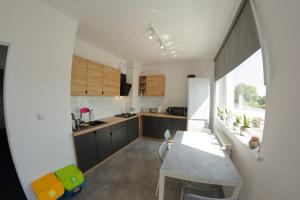 a kitchen with a table and a dining room at Marynarska 57 in Darlowko