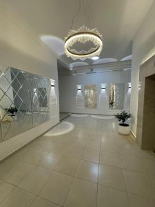 a large room with a chandelier and a tiled floor at Paradise Apartment in Batumi