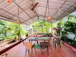 a patio with a table and chairs and trees at iha ayurveda resort in Varkala +8 photos