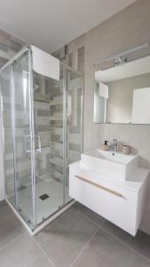 uma casa de banho com uma cabina de duche em vidro e um lavatório. em Villa Corona Cordis em Banjole
