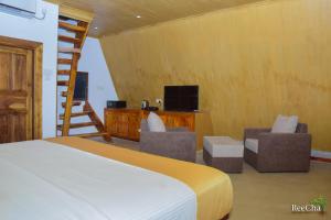 1 Schlafzimmer mit einem Bett, 2 Stühlen und einer Leiter in der Unterkunft Reecha Organic Resort Jaffna in Kilinochchi