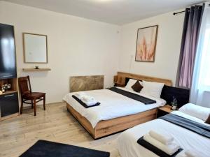 een hotelkamer met 2 bedden en een stoel bij Къща за гости Вила Победа 