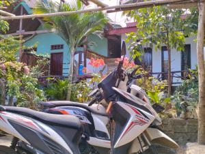 ein Motorroller, der vor einem Haus parkt in der Unterkunft Nadil Homestay in Kuta Lombok