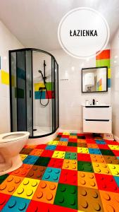 a bathroom with a colorful floor with a toilet at Kolorowe Domki in Jarosławiec