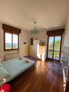 1 dormitorio con 1 cama en una habitación con suelo de madera en Un Tetto Sulle Nuvole by SMART-HOME, en Tagliolo Monferrato