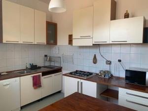 cocina con armarios blancos y encimera en Un Tetto Sulle Nuvole by SMART-HOME, en Tagliolo Monferrato