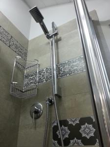 La salle de bains est pourvue d'une douche avec une porte en verre. dans l'établissement Mansarda Palatina, à Turin
