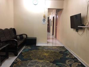 a hallway with a living room with a couch and a television at Homestay Abdul in Kampung Banggul Gucil