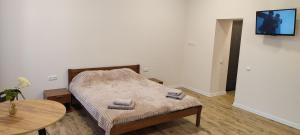 a small bedroom with a bed and a table at SweetHomeApartment in Kamianets-Podilskyi