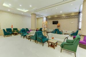 a waiting room with green and purple chairs at Hayah Plaza Hotel in Medina