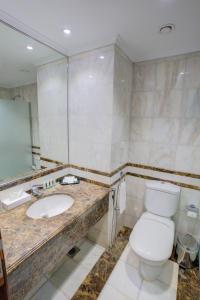 a bathroom with a toilet and a sink at Hayah Golden Hotel in Al Madinah