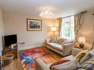 a living room with two couches and a tv at Corner Cottage, Dennington in Framlingham