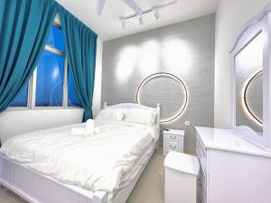 a bedroom with a white bed and blue curtains at SKS Habitat 461 2BR 4-5pax Larkin Johor Bahru in Johor Bahru