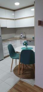 cocina con mesa y 2 sillas verdes en Filip Apartment, en Mavrovo