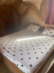 Una cama en una habitación con estrellas negras. en המערה הפוריה בפוריה, en Poriyya
