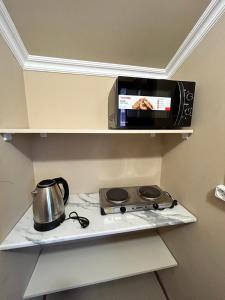a kitchen with a microwave and a tea kettle on a stove at Комнаты в собственном доме in Vanadzor