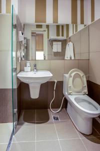 a bathroom with a toilet and a sink at Hotel101 - Fort in Manila