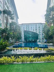 a fountain in front of a building with a glass building at City center residents Pool view in Pattaya Central