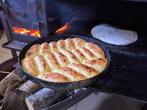 a pan of bread is cooking on a grill at Guesthouse Angelina in Ushguli