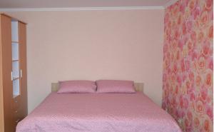 1 dormitorio con 1 cama con colcha rosa en Julia Apartment Riga Imanta, en Riga