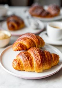 twee croissants op een wit bord op een tafel bij Apartments for you in Matera