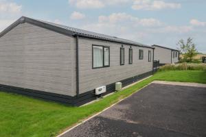 a grey house with a parking lot next to it at Penmarlam Lodge Retreat 12 in Fowey