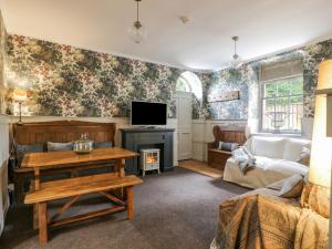 a living room with a couch and a tv at Trefoil Cottage in Biggar