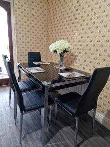 een eettafel met stoelen en een vaas met bloemen bij Females Only - Private Bedrooms in Dublin in Lucan