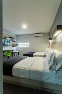 a bedroom with a large bed and a desk at HOTEL LEMON GREEN -Zona Expo Frente al Centro de Convenciones in Guadalajara