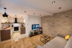 sala de estar y cocina con pared de ladrillo en Villa Martinis, en Split