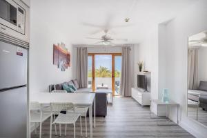 un soggiorno bianco con tavolo e divano di Garden City Pool and Sea view by LoveTene a Playa Fañabe