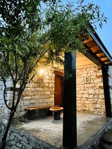 a stone building with a bench and a tree at COSY STONES bY MANOKUR-E- BASA in Minapin +17 photos
