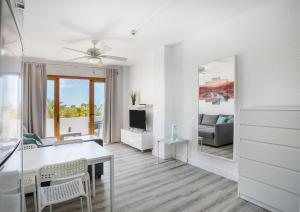 un soggiorno bianco con tavolo e specchio di Garden City Pool and Sea view by LoveTene a Playa Fañabe