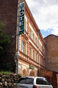 a car parked in front of a building with a sign at Atlantik Hotel in Vyborg