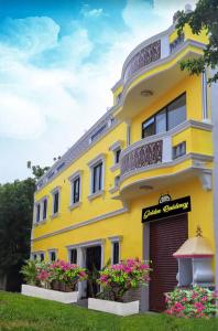 a yellow building with flowers in front of it at Paradise Golden Residency in Kottakupam