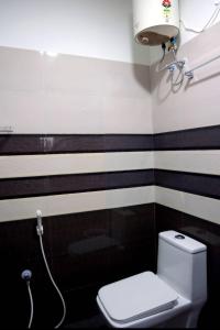 a bathroom with black and white striped walls and a toilet at Paradise Golden Residency in Kottakupam