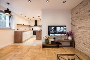 een woonkamer met een televisie en een bakstenen muur bij Villa Martinis in Split