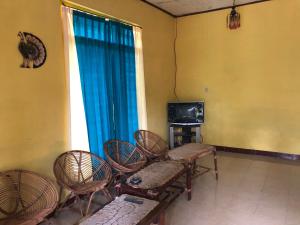 um quarto com cadeiras e uma televisão e uma janela em Atha house em Krogowanan