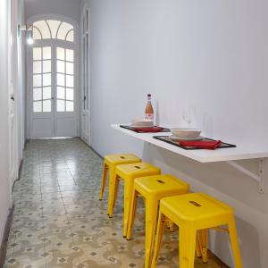 kuchnia z żółtymi stołkami i blatem w obiekcie GIRONA w Barcelonie