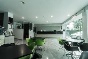 un ristorante con sedie e tavoli verdi in una stanza di HOTEL LEMON GREEN -Zona Expo Frente al Centro de Convenciones a Guadalajara