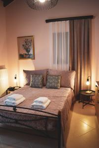 een slaapkamer met een bed met 2 kussens erop bij Rose Garden Villa 
