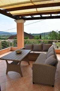 een patio met een bank en een tafel bij Rose Garden Villa 