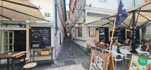 una calle estrecha con mesas y sillas y un restaurante en Apartment Keymaster's Hideaway, en Liubliana