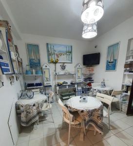 a room with two tables and chairs and a tv at La Battigia B&B in Trabia