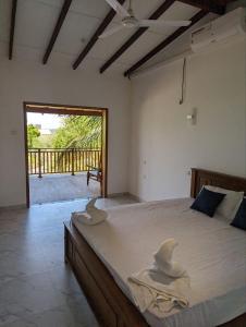 a bedroom with a large bed with two hats on it at Kirinda Heaven - Yala in Kirinda